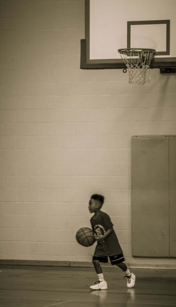 Person dribbling basketball in indoor gym