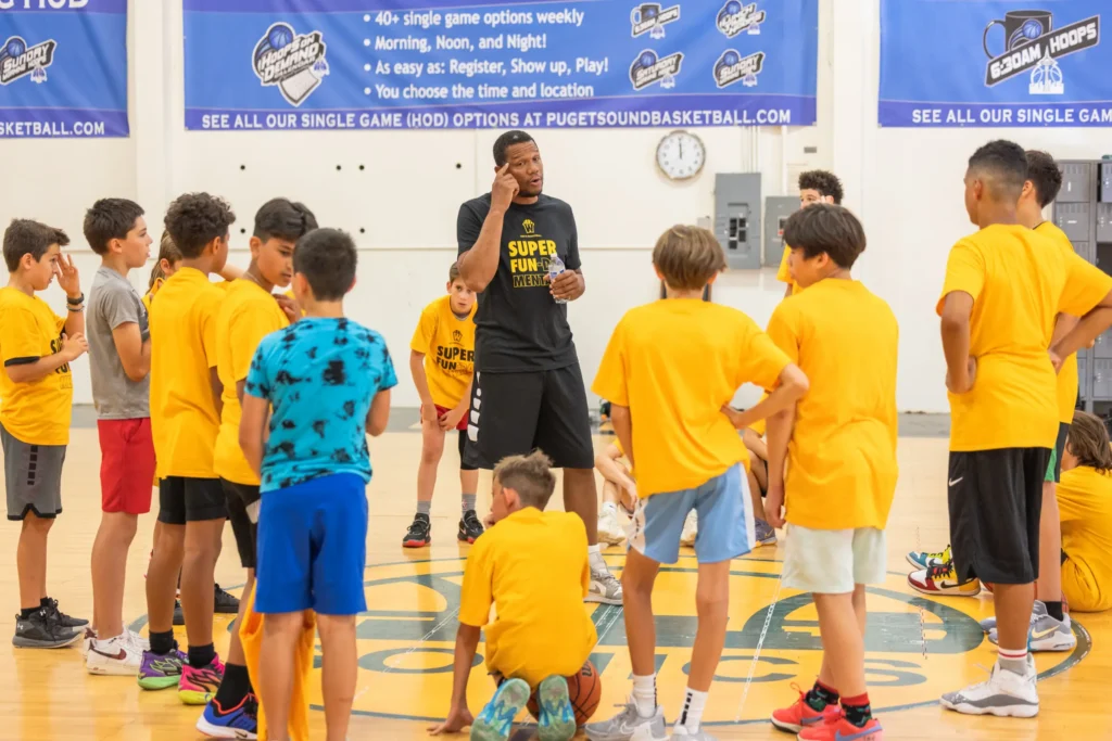Coach instructing youth basketball players in gym