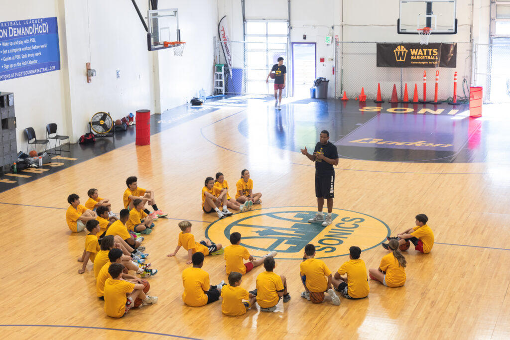 Coach addressing youth basketball team on court