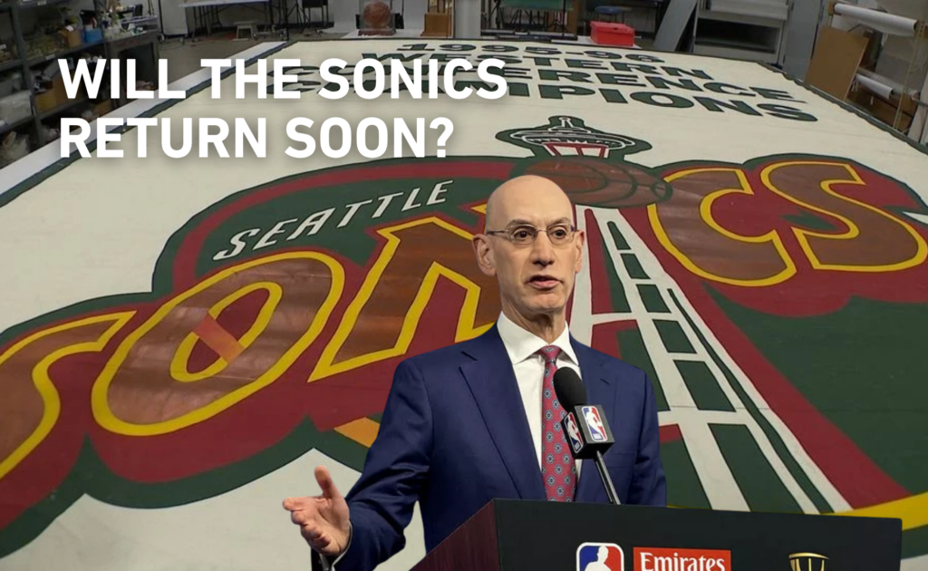 Man at podium in front of Sonics logo